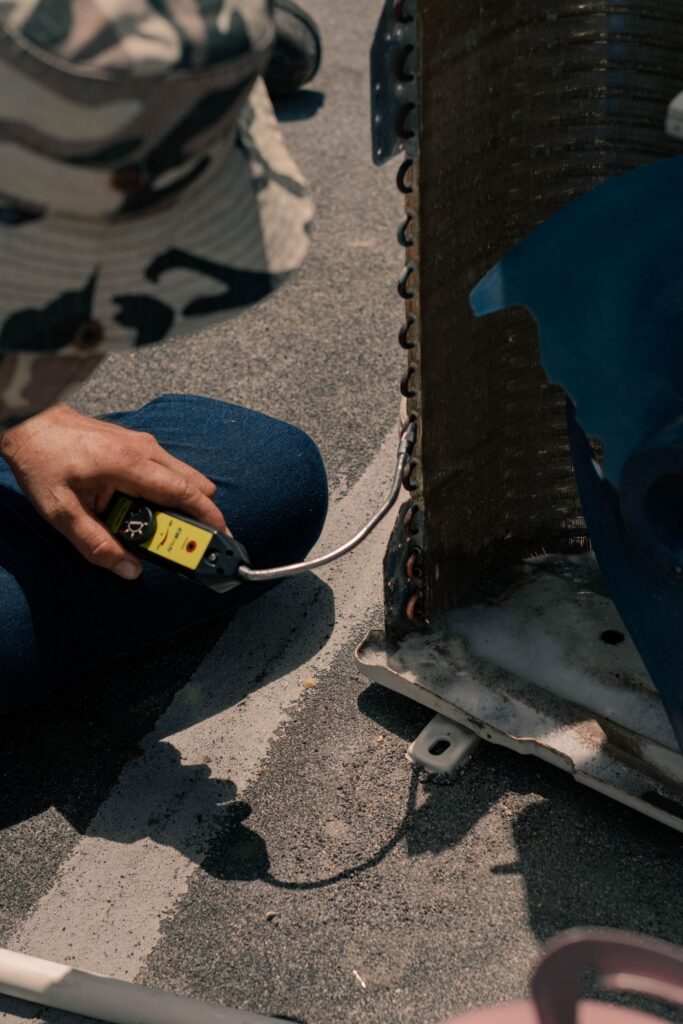 Técnico inspeccionando unidad de aire acondicionado antigua