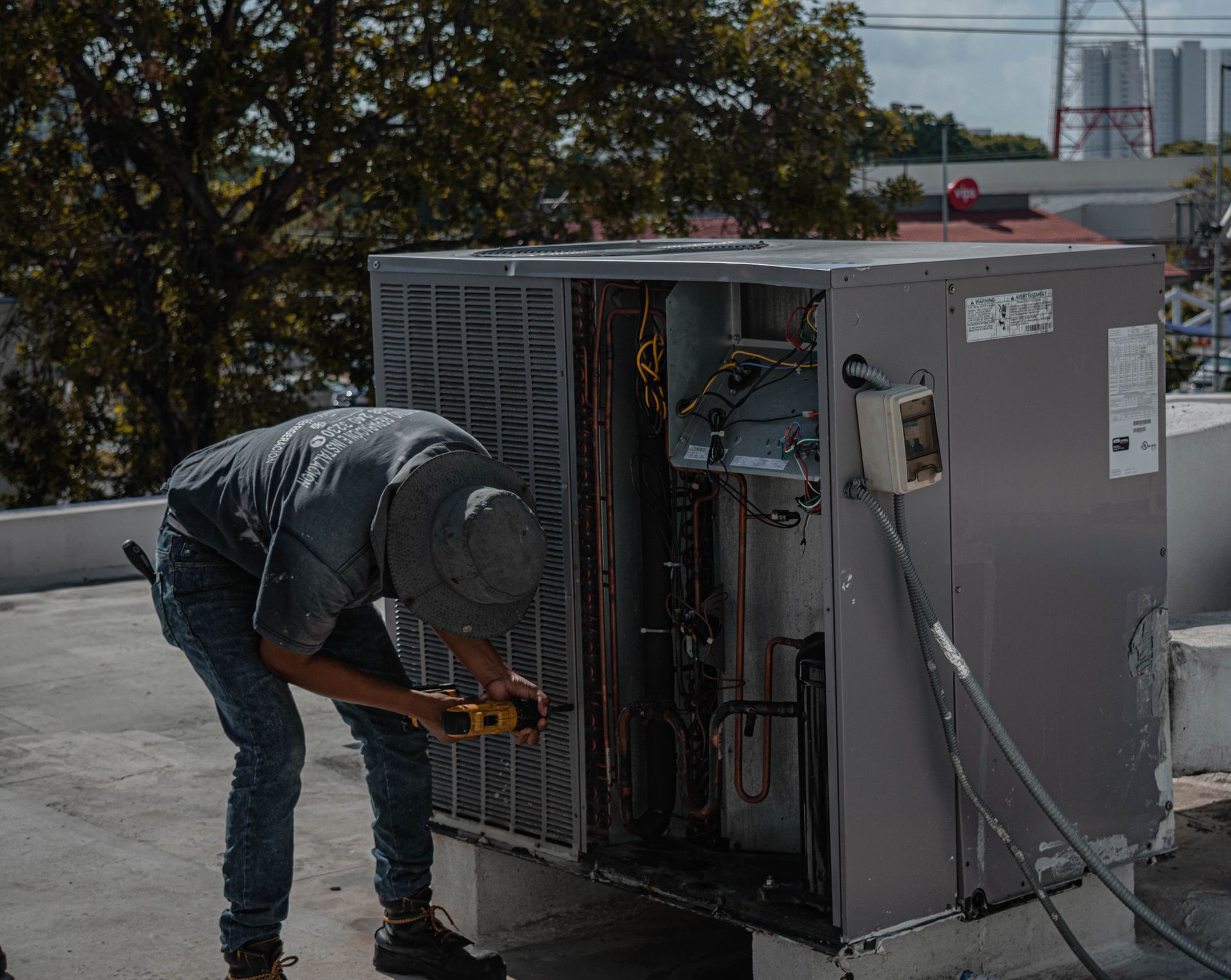 Técnico instalando la carcasa de una unidad de aire acondicionado durante el mantenimiento