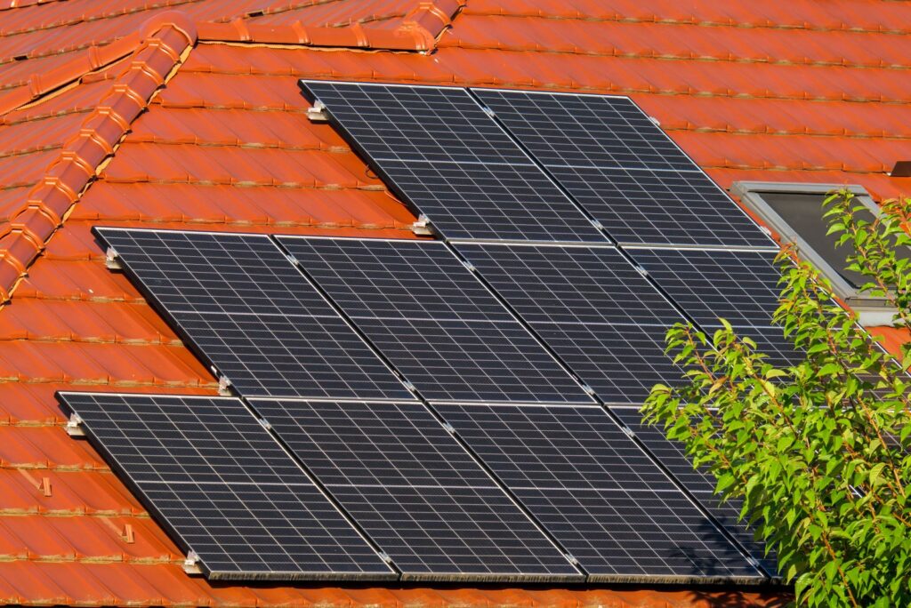 Instalación de placas solares fotovoltaicas sobre un tejado de teja en una vivienda unifamiliar